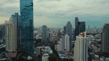 Gün doğumunda Bangkok ufuk çizgisinin nefes kesici hava manzarası, yumuşak sabah ışığı yüksek binalar ve kentsel manzara üzerine sıcak bir parıltı yayıyor..