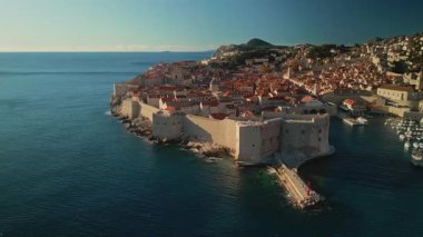 Sakin deniz kıyısındaki Lovrijenac ve Dubrovnik kasabaları hareket halindedir. Hırvatistan 'ın havacılık panoramasındaki kaleyle korunan limanı olan düzenli bir ortaçağ şehrine seyahat
