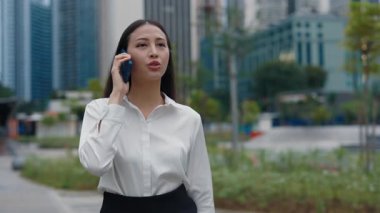 Dışarıda iş kadını dolanıyor, sokakta yürüyor ve telefonda sorunlar hakkında konuşuyor. Smartphone 'da çok ciddi bir konuşma yapan oldukça ciddi bir kadın. Halk ve Teknoloji Konsepti