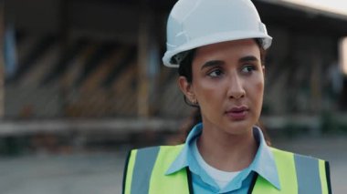 Güvenli Üniforma Giyip Denetleme Kutuları Giyen Güvenilir Latin İşçi Gemicilik İskelesinde Yürüyor. Genç kıvırcık saçlı kadın dışarı çıkıp etrafa bakınıyor. Mühendis Konsepti