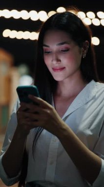 Dikey video. Kız elinde telefonunu tutuyor ve New Mekan 'da arkadaşlarıyla sohbet ediyor. Kafe Müdürü, Smartphone kullanarak Sosyal Medya 'da müşterilere cevap veriyor. Halk ve Teknoloji Konsepti