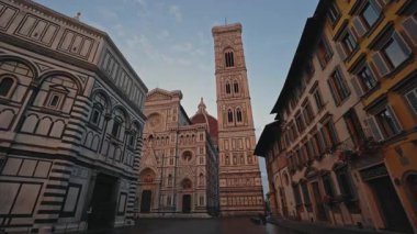 FLORENCE, İtalya - 15 Ağustos 2024: Eski kentteki Aziz John ve Giotto Bell Kulesi 'nin Baptistery yakınlarındaki Ortaçağ Santa Maria del Fiore tapınağı. Mavi gökyüzüne karşı kare üzerinde büyülenmiş antik mimari