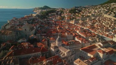 Dubrovnik katedrali ve eski şehir kamerasındaki tarihi kırmızı çatılı binalar ilerliyor. Adriyatik deniz kıyısı kuş bakışı manzaralı ortaçağ kasabasının şaşırtıcı manzarası
