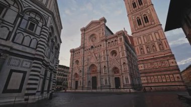FLORENCE, ITALY - 15 Ağustos 2024: Aziz John 'un Baptistery' si ve eski kasaba merkezinde yüksek kulesi olan antik Santa Maria del Fiore tapınağı. Günbatımında şehir meydanında dini hizmetler için binalar