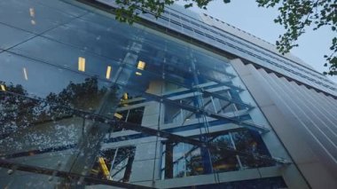 Sokak alçak açılı çekimlerde modern iş merkezinin ön cephesinde cam duvar ve panjurlar. Şık ofis binası Alacakaranlık 'taki banka ve şirket merkezi için ideal.