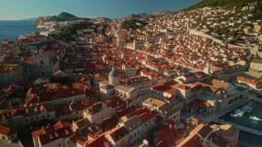 Güneşli bir günde Dubrovnik 'teki deniz limanının önünden geçen ortaçağ mimari mirası. Eski binaları ve marina havası manzarası olan popüler bir turistik mekan. Yaz tatili