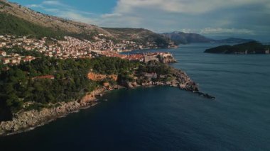 Güneşli bir günde Dubrovnik yakınlarındaki Rocky Pine kıyı şeridi yukarıdan görülüyor. Bu ikonik Adriyatik tatil beldesinin sahil kayalıklarında kayan kamera büyüleyici doğal güzellikleri gösteriyor..