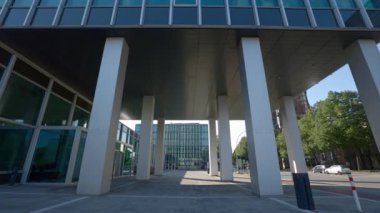 HAMBURG, Almanya - 23 Eylül 2024: Beyaz sütunlar şehir merkezindeki Hamburg-Sud-Gebaude yapısını destekliyor. Güneşli şehir caddesinde ticari gayrimenkullerin modern mimari simgesi