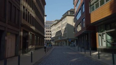 HAMBURG, Almanya - 23 Eylül 2024: Dar sokaklardaki yenilenmiş sanayi binaları ve asfalt yollar. Yazın Avrupa 'da dükkanların ve kafelerin önünden geçen bir adam. Seyahat hedefi