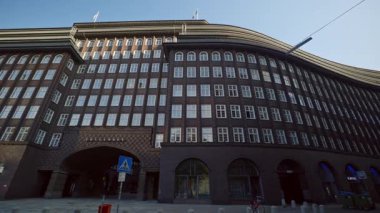 HAMBURG, GERMANY - 23 Eylül 2024: Kontorhaus bölgesinde kahverengi tuğlalı ve parlak pencereli çok katlı Chilehaus. Geçen yüzyılın mimari tarzını temsil eden klasik ofis binası