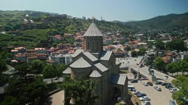 TBILISI, GEORGIA - 15 Ocak 2023: Tiflis, Gürcistan 'daki Metekhi Kilisesi' nin havadan görünüşü. Tarihi Ortodoks kilisesi eski kasaba mimarisi ile çevrili kayalık bir tepede duruyor.
