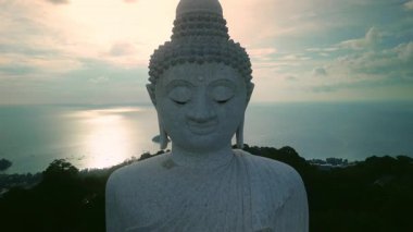 Phuket Büyük Buda heykelinin güzel yüzü, sakin günbatımı okyanus manzarasına karşı. Dağda Budizm dinini sunan şaşırtıcı Asya kültürü anıtı. Farkındalık kavramı