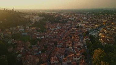 Tepenin yamacında Villa Francescatti ile birlikte Verona 'nın yerleşim alanının altın saat görüntüsü. Sıcak akşam ışığı çatıların ve ağaçların üzerine uzun gölgeler salıyor..