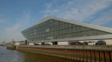 HAMBURG, Almanya - 23 Eylül 2024: Altona Altstadt 'taki eski İngiltere feribot iskelesi yakınlarındaki Elbe nehri üzerindeki liman ofis binası. Toprak döşeme üzerindeki liman iş kontrolünün idari merkezi