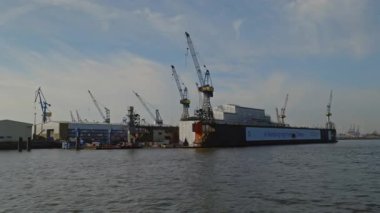 HAMBURG, ALMANY - 23 Eylül 2024: Elbe nehri üzerindeki şehir limanında kule vinçleri ile kuru rıhtımlar. Sakin limandaki gemilerin tamir hizmetleri için donatılmış tersane. Modern şehrin endüstriyel kompleksi