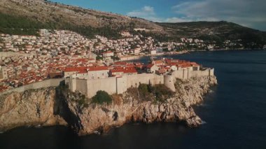 Eski St. Lawrence kalesi, dik yamaçta temiz bir kasaba, yükselen dağ kameralarına karşı. Dubrovnik 'teki deniz kıyısındaki antik kale mimari simgesi Hırvatistan hava manzarası