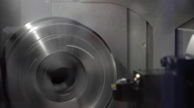 CNC torna makinesindeki dönen metal diskin yüksek hızdaki görüntüsünü kapat. Metal işleme, hassas mühendislik, makine ve modern üretim teknolojisi endüstriyel konsepti.
