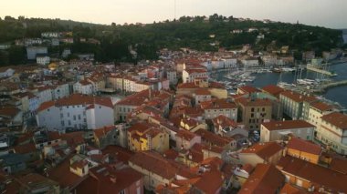 Akşam güneşi kırmızı çatıdaki körfezi aydınlatırken renkli evler kıyı tepesini kaplıyor. Eski kasaba, dar sokaklar ve teknelerle otantik Akdeniz cazibesini sergiliyor