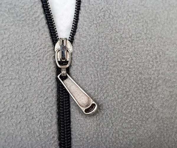 Gri kazaklı gümüş bir fermuar.