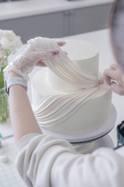 Beyaz düğün pastası süsleme işlemi katmanlı