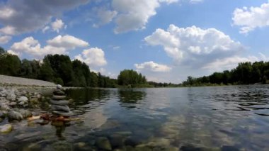 Ticino parkındaki nehir kıyısında taş dengesi.