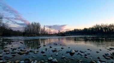 Ticino parkında gün batımı nehirden görüldü.