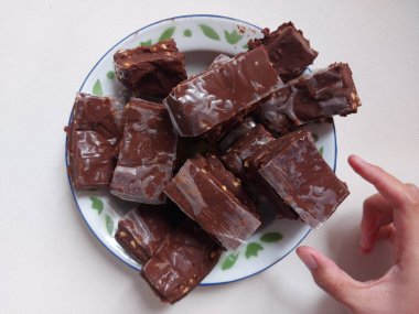 Çukulata parçaları. Emaye tabağında servis ediliyor. İzole edilmiş arkaplan beyaz