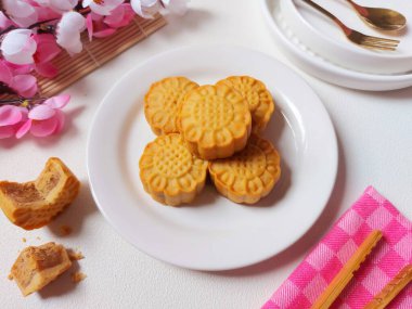 Beyaz tabakta ay çöreği. Geleneksel Çin pastanesi ürünü. Sonbahar festivalinin ortasında yenmiş. Yumuşak ve tatlı tat.