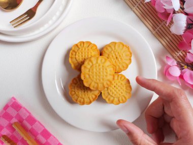 Beyaz tabakta ay çöreği. Geleneksel Çin pastanesi ürünü. Sonbahar festivalinin ortasında yenmiş. Yumuşak ve tatlı tat.