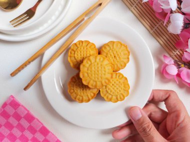 Beyaz tabakta ay çöreği. Geleneksel Çin pastanesi ürünü. Sonbahar festivalinin ortasında yenmiş. Yumuşak ve tatlı tat.