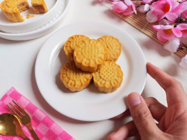 Beyaz tabakta ay çöreği. Geleneksel Çin pastanesi ürünü. Sonbahar festivalinin ortasında yenmiş. Yumuşak ve tatlı tat.
