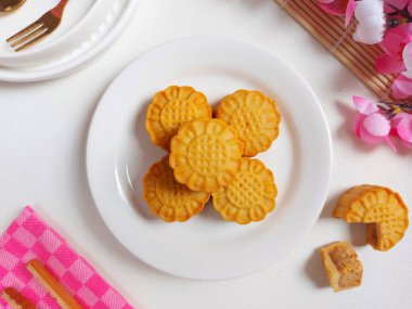 Beyaz tabakta ay çöreği. Geleneksel Çin pastanesi ürünü. Sonbahar festivalinin ortasında yenmiş. Yumuşak ve tatlı tat.