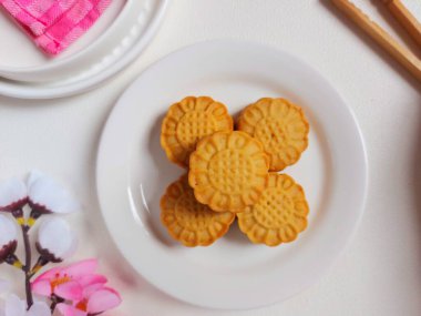 Beyaz tabakta ay çöreği. Geleneksel Çin pastanesi ürünü. Sonbahar festivalinin ortasında yenmiş. Yumuşak ve tatlı tat.