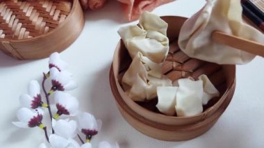 Kadın eli bambu buharlı tencereye çiğ mantı ya da gamsum koyar. Geleneksel Çin yemekleri. Tadı tuzlu.