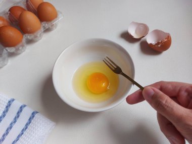 Yemek hazırlama fotoğrafçılık konsepti. Beyaz kasede yumurta çırpmak. İzole edilmiş arkaplan beyaz.
