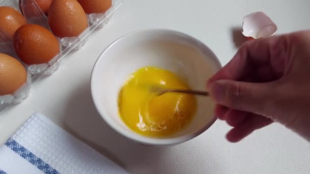 白いボウルに卵を泡立てる 白で隔離された背景 食の準備映像のコンセプト — ストック動画