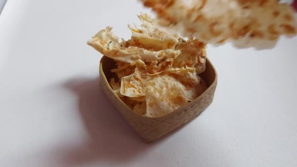 ボウルからRempeekレボンを取ります Rempeyekはインドネシアの伝統的なチップです 小麦粉とレボンエビから作られています サクサクとカリカリ 風味豊かな味 — ストック動画
