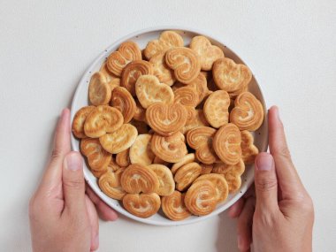  Kalp şeklinde şeker serpiştirilmiş bisküviler beyaz tabakta. İzole edilmiş arkaplan beyaz.