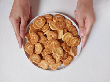  Kalp şeklinde şeker serpiştirilmiş bisküviler beyaz tabakta. İzole edilmiş arkaplan beyaz.