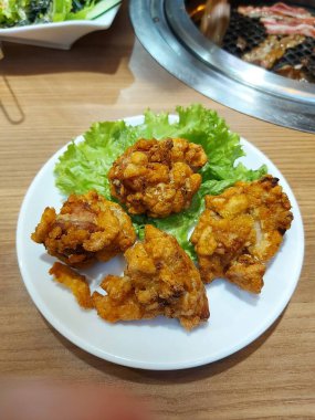 Karaoke usulü tavuk mu, Japon usulü kızarmış tavuk mu? Marullu beyaz tabakta servis ediliyor. Tadı tuzlu