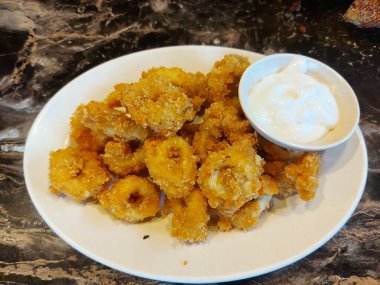 Kalamar halkaları. Mürekkep balığı un hamuruna sarılıp kıtır kıtır olana kadar kızartılmış.