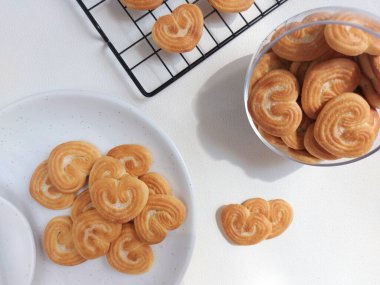 Beyaz tabakta kalp şeklinde şeker serpiştirilmiş bisküviler. İzole edilmiş arkaplan beyaz.