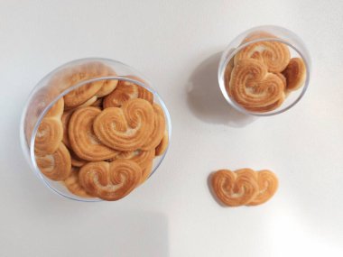 Beyaz tabakta kalp şeklinde şeker serpiştirilmiş bisküviler. İzole edilmiş arkaplan beyaz.