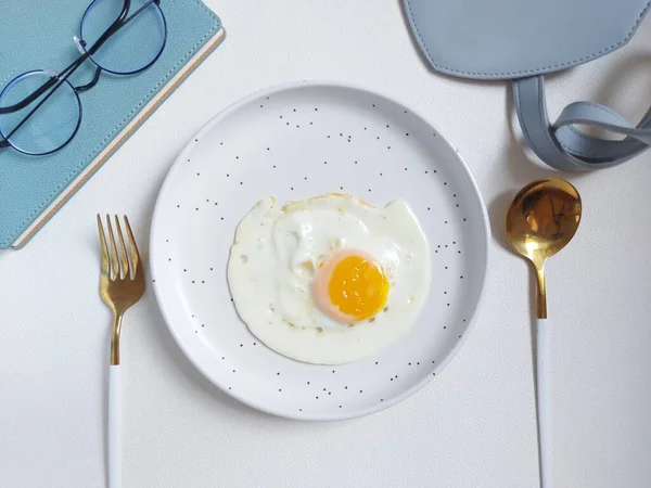 Sunny side up egg on white plate. Isolated background in white