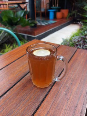 Hot lemon tea on the glass. Served on the table