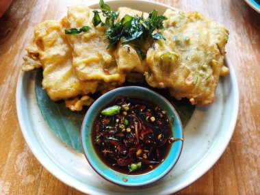 Tempe mendoan. It is traditional snack from indonesia. Made from tempeh wrapped with flour. Usually served with sweet soy sauce and chili. Savory taste.