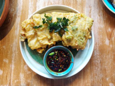 Tempe mendoan. It is traditional snack from indonesia. Made from tempeh wrapped with flour. Usually served with sweet soy sauce and chili. Savory taste.
