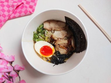 Chicken ramen noodle on paper bowl. It is authentic food from japan. Usually consist of noodle, soup, boiled egg, spring onion, seaweed, chicken meat. Completed with chopsticks. Savory taste