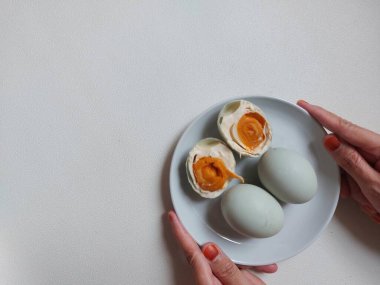 Salted Egg. It's a dish made from eggs that are preserved by salting them.  Most of the eggs that are salted are duck eggs, although it does not rule out other eggs