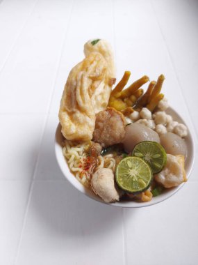Baso aci. It is popular food from Indonesia. Similiar with meat ball but it made from tapioca flour. Completed with noodle,chicken feet, lime, and dry dumpling. Savory taste. Served on a bowl. 